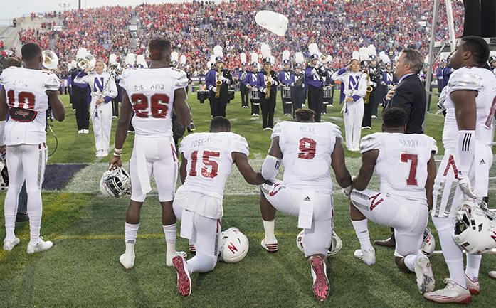 Nebraska linebacker Michael Rose-Ivey (15), defensive end DaiShon Neal (9) and linebacker Mohamed Barry (7) kneel during the national anthem before the teams NCAA college football game against Northwestern in Evanston, Ill., on Saturday, Sept. 24, 2016. Rose-Ivey said Monday he and his family have received racially charged criticism on social media, and said the responses show why the protest is necessary. (Matt Ryerson/Journal Star via AP)