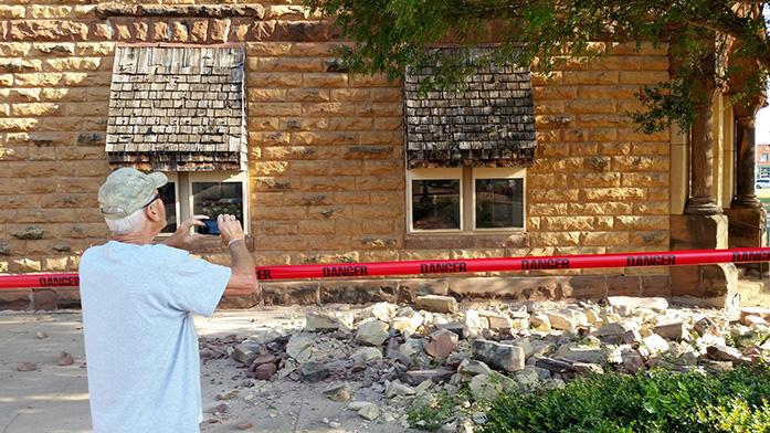 Steve Gibson, of Pawnee, takes photos of damage to a building in downtown Pawnee, Okla., following a 5.6 magnitude earthquake that hit just after 7 a.m., in north-central Oklahoma, Saturday, Sept. 3, 2016. (David Bitton/The News Press via AP)