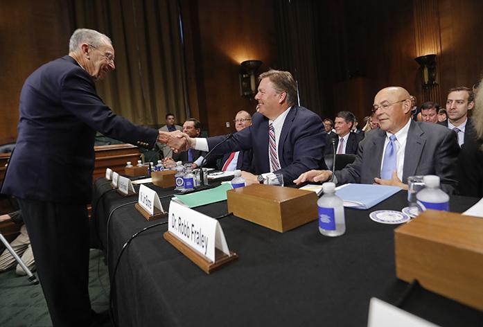 Senate Judiciary Committee Chairman Sen. Charles Grassley, R-Iowa, left, greets Jim Blome, President & CEO, Bayer CropScience North America, and Dr. Robb Fraley, right, Executive Vice President & Chief Technology Officer, Monsanto Company, on Capitol Hill in Washington, Tuesday, Sept. 20, 2016, prior to the start of the committees hearing on a proposed $66 billion merger of American seed and weed-killer company Monsanto and German medicine and farm chemical maker Bayer. (AP Photo/Pablo Martinez Monsivais)