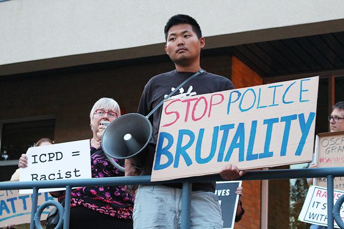 Protesters hold signs and chant outside the city hall during a city council meeting on Tuesday, Oct. 4, 2016. They were chanting about how they don't want a "white man" in charge anymore. (The Daily Iowan/Gage Miskimen)