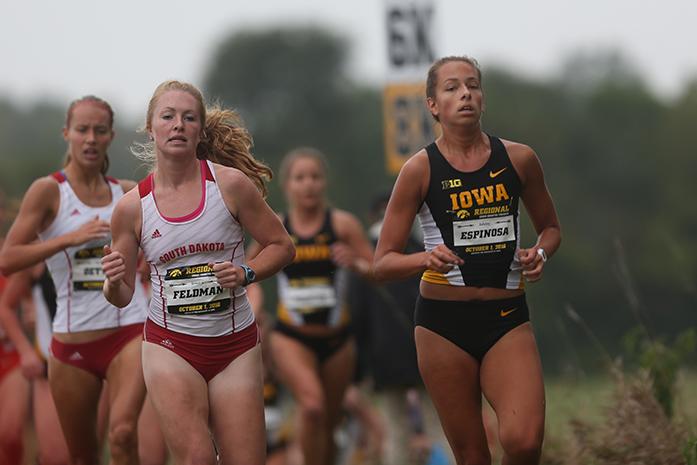 Iowa runner Ashely Espinosa and South Dakota runner Jessica Feldman are neck and neck as the round the first lap. Tess Wilberding placed 2nd for the Hawkeyes in the Women's 6k. (The Daily Iowan/Karley Finkel)
