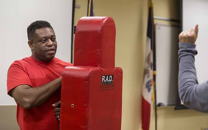 Alton Poole, an R.A.D. instructor, holds a dummy for attendees to practice defensive moves during a Rape Aggression Defense (R.A.D.) Class at the Department of Public Safety in Iowa City on Wednesday, Oct 5, 2016. R.A.D. classes are basic self-defense classes for women. (The Daily Iowan/Ting Xuan Tan)