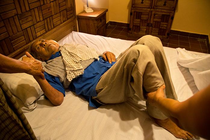 Pedro Sandoval is slowly guided onto his bed as he readies for a nap in Cuatla, Morelos, Mexico. Suffering from skin cancer and several months into his treatment Pedro must make daily trips to specialists for dialysis and radiation treatment. The specialist’s office is about 45 minutes away from his house forcing him to stay the majority of the week at a family members home closer to the clinics. Even though it serves him better to do so, he still complains that he'd rather be at his own home rather than be a burden on another family. While family in Mexico take care of him, his children across the border check in on his health via phone-call whenever possible and give monetary support when needed. (The Daily Iowan/Anthony Vazquez)