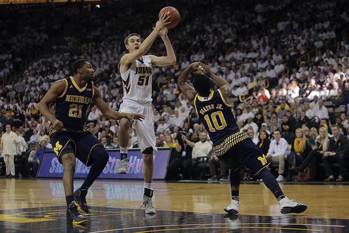 Iowa forward Nicholas Baer goes up for a layup against Michigan's Zak Irvin and Derrick Walton Jr. during the Iowa-Michigan game in Carver-Hawkeye Arena on Sunday, Jan. 17, 2015. The Hawkeyes defeated the Wolverines, 82-71. (The Daily Iowan/Margaret Kispert)