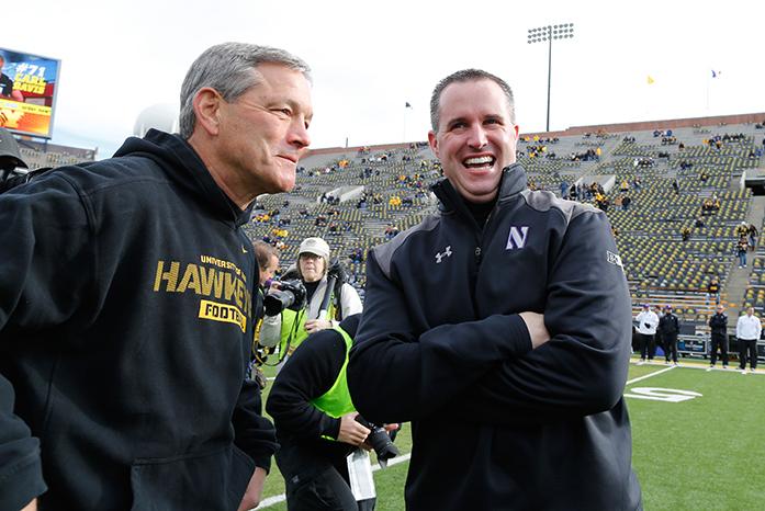 FILE - In this Oct. 26, 2013, file photo ,Iowa coach Kirk Ferentz, left, talks with Northwestern coach Pat Fitzgerald before their NCAA college football game Saturday, at Kinnick Stadium in Iowa City, Iowa. The two teams meet on Saturday. (AP Photo/Brian Ray, File)
