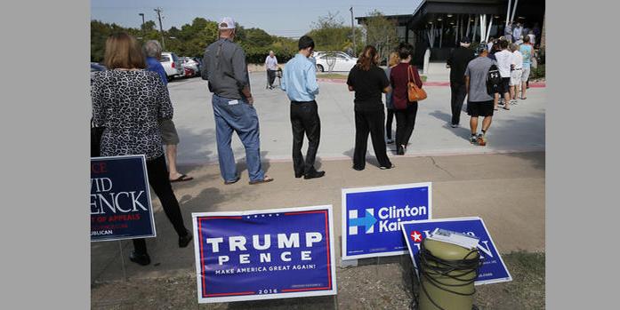 Early voters stand by campaign signage as they wait in line at a voting location, Thursday, Oct. 27, 2016, in Dallas. Republican presidential candidate Donald Trump is again raising the possibility of election rigging in a tweet that follows unsubstantiated claims in Texas of voters having their ballots changed.(AP Photo/Tony Gutierrez)