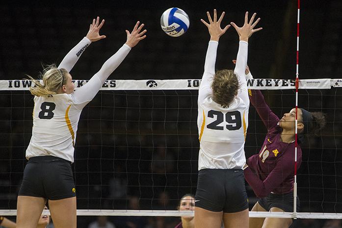 Minnesota outside hitter Alexis Hart hits a ball between Iowas Reghan Coyle and Jess Janota during a volleyball game in Carver-Hawkeye Arena on Friday, October 21, 2016. Minnesotas Golden Gophers defeated the Hawkeyes, 3-2, at home. (The Daily Iowan/Joseph Cress)