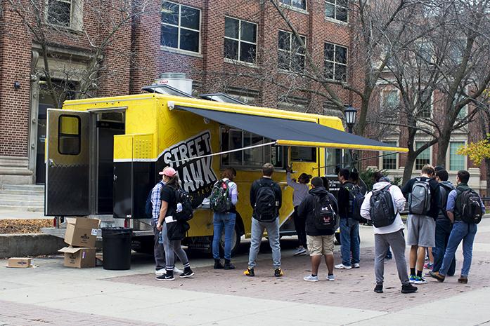 Students+line+up+outside+the+Tippie+College+of+Business+to+food+from+the+Street+Hawk+Food+Truck.+Currently%2C+there+are+no+designated+food-truck+parking+spaces+in+Iowa+City+and+theres+a+general+ban+on+food+trucks%3B+with+a+few+exceptions+like+the+Street+Hawk.+%28The+Daily+Iowan%2FOsama+Khalid%29