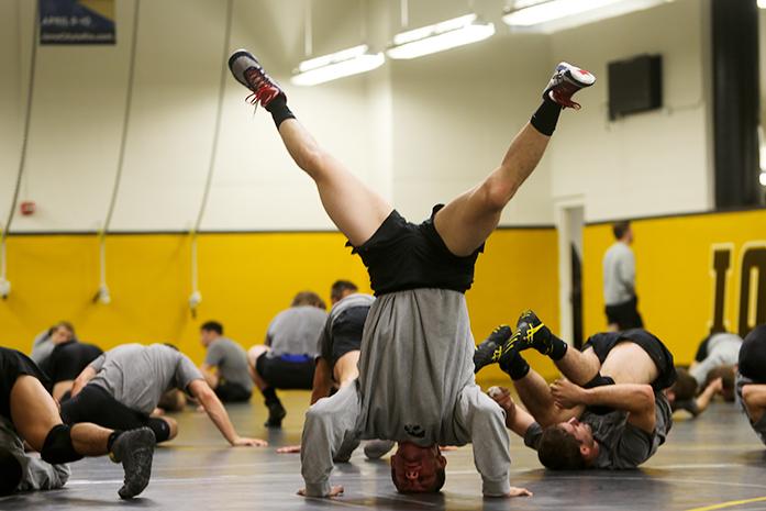 Members of the University of Iowa Wrestling team stretch and warm up after the Wrestling Media Day at the Carver-Hawkeye Arena on November 2, 2016.(The Daily Iowan/Osama Khalid)