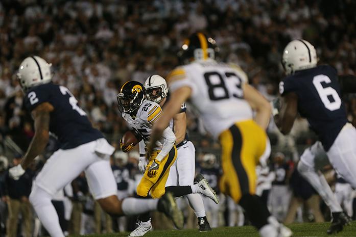 Iowa running back Akrum Wadley runs in between Penn State defenders on his way to the end zone on Nov. 5. The Hawkeyes lost to the Nittany Lions, 41-14. (The Daily Iowan/Margaret Kispert)