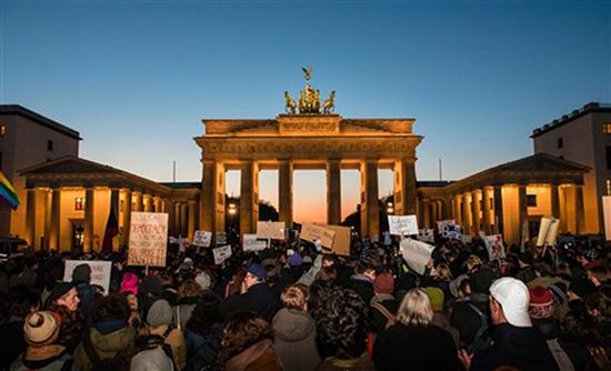 Demonstrators protest  near the American Embassy in front of the Brandenburg Gate in Berlin,†Germany,  Saturday Nov. 12, 2016. About 300 people protested Donald Trumpís election as the next American president outside the U.S. Embassy by the German capitalís landmark Brandenburg Gate. The peaceful protesters Saturday waved signs with slogans like ìLove Trumps Hateî and ìMake Love, Not Trump.î  (Gregor Fischer/dpa via AP)