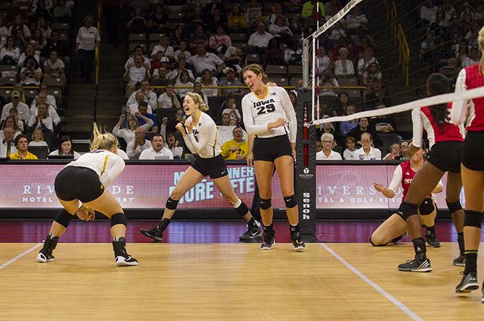 Iowa players celebrate after Iowas no. 19 Lauren Brobst and no. 29 Jess Janota scores a point with their block during a volleyball match at the Carver Hawkeye Arena in Iowa City on Saturday, Oct 8, 2016. Iowa defeated Indiana 3-0. (The Daily Iowan/Ting Xuan Tan)