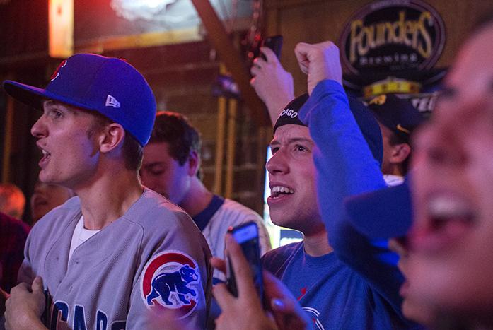 Fans celebrate after Chicago prevented Cleveland from scoring during a screening of the MLB World Series game at The Sports Column in Iowa City on Wednesday, Nov. 2, 2016. Chicago tied with Cleveland 3-3 in the lead up to this game. (The Daily Iowan/Ting Xuan Tan)