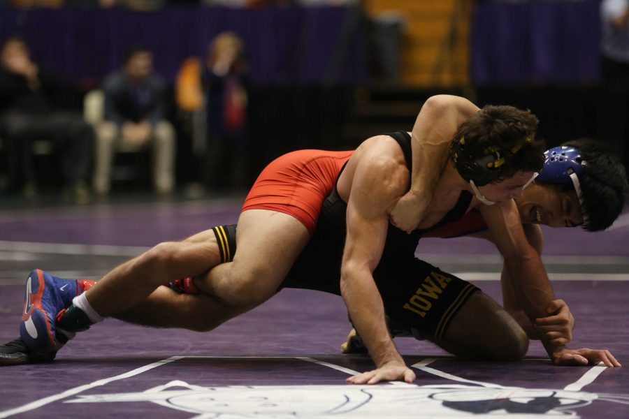 Iowa 125-pounder Thomas Gilman (black) wrestles Americans Josh Terao during the 54th Annual Ken Kraft Midlands Championships in Welsh-Ryan Arena on Friday, Dec. 30, 2016. Gilman defeated Terao by deacon, 8-6. Iowa won first place in the team completion with 150.5 points. (The Daily Iowan/Joshua Housing)