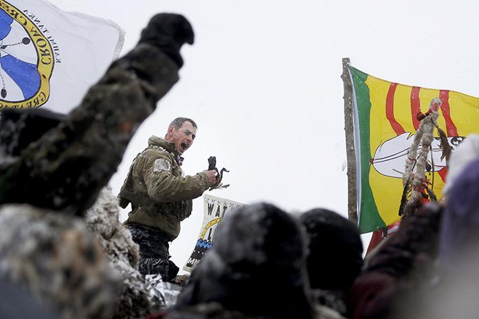 United States Navy veteran Kash Jackson speaks during a march with fellow veterans and Native American to a closed bridge outside the Oceti Sakowin camp where people have gathered to protest the Dakota Access oil pipeline in Cannon Ball, N.D., Monday, Dec. 5, 2016. (AP Photo/David Goldman)