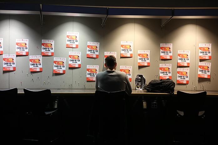 A UI student studies in front of posters at Adler Journalism Building on Wednesday, January 25, 2017. The posters are for JoyRun internships on campus, a company that is innovating local delivery with a community first philosophy. (The Daily Iowan/Rachael Westergard)