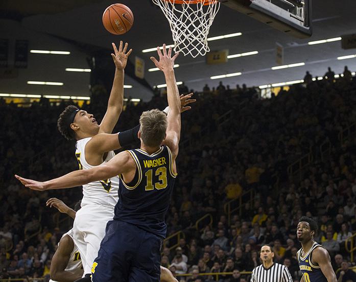 Iowa forward Cordell Pemsl attempts a layup over Michigan forward Mortiz Wagner during a mens basketball game in Carver-Hawkeye Arena on Sunday, Jan. 1, 2017. The Hawkeyes defeated the Wolverines, 86-83 in OT. (The Daily Iowan/Joseph Cress)