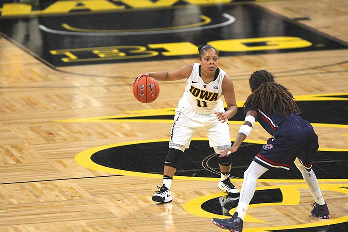 Iowa guard Tania Davis dribbles the ball against a defender at mid-court during the Iowa-Robert Morris game in Carver-Hawkeye Arena on Friday, Dec. 9, 2016. The Hawkeyes defeated the Colonials, 81-60. (The Daily Iowan/Margaret Kispert)