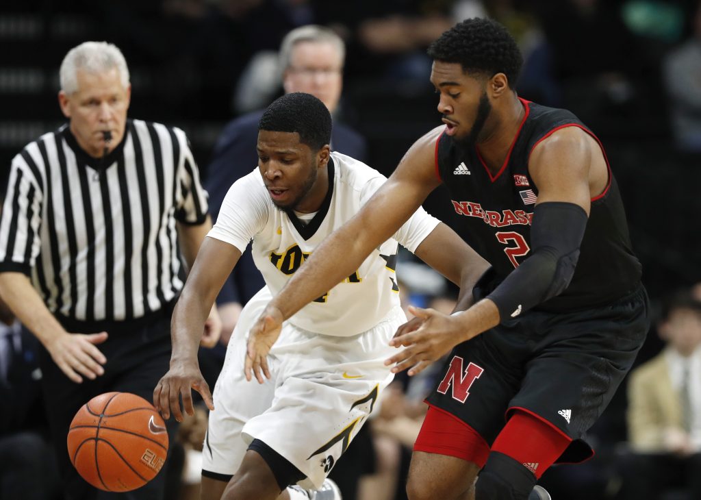 Iowa guard Isaiah Moss, center, fights for the ball with Nebraska forward Jeriah Horne, right, during the first half of an NCAA college basketball game, Sunday, Feb. 5, 2017, in Iowa City, Iowa. (AP Photo/Charlie Neibergall)