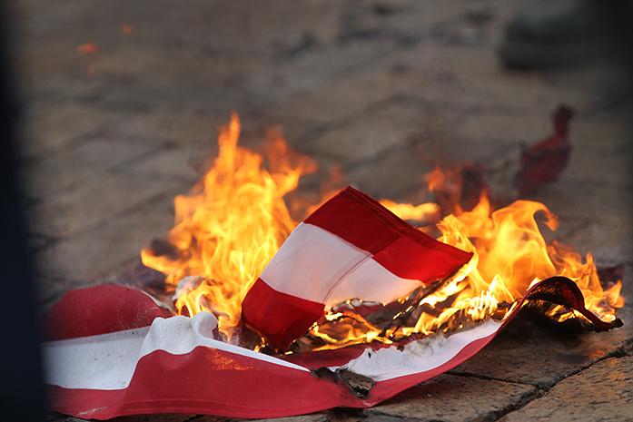 An American flag is burned on the pedestrian mall along Clinton Street on Thursday, Jan. 26, 2017.(David Scrivner/Iowa City Press-Citizen)