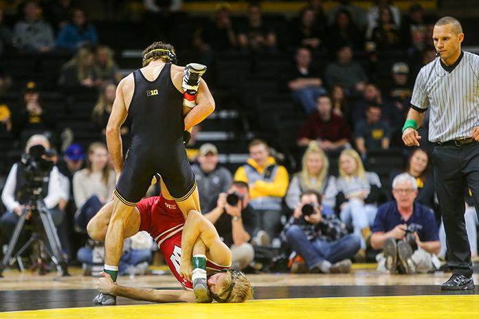 Iowas Thomas Gilman towers over Wisconsins Jens Lantz during the Iowa v. Wisconsin wrestling bout, in Carver-Hawkeye  in Iowa City, Iowa  on Friday, Feb. 3, 2017. The Hawkeyes defeated the Badgers with a team overall of 33-8. (The Daily Iowan/Anthony Vazquez)