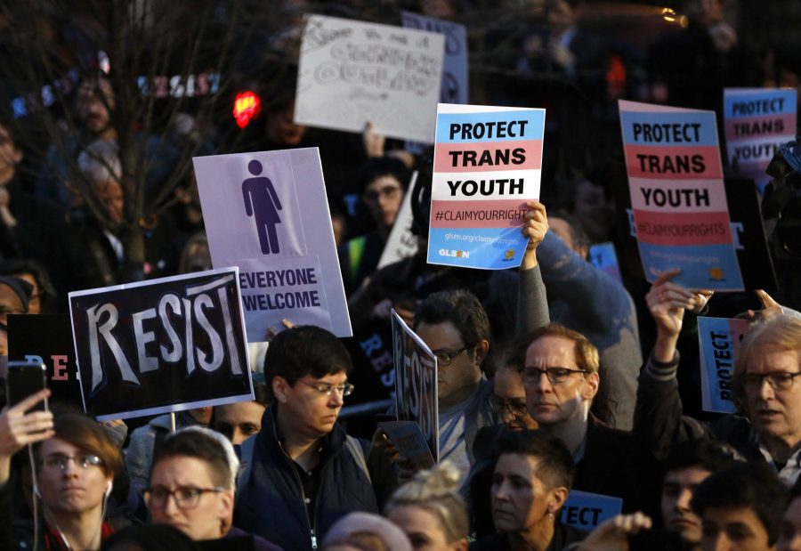 Protesters hold signs at a rally in support of transgender youth, Thursday, Feb. 23, 2017, at the Stonewall National Monument in New York. They were demonstrating against President Donald Trumps decision to roll back a federal rule saying public schools had to allow transgender students to use the bathrooms and locker rooms of their chosen gender identity. The rule had already been blocked from enforcement, but transgender advocates view the Trump administration action as a step back for transgender rights. (AP Photo/Kathy Willens)