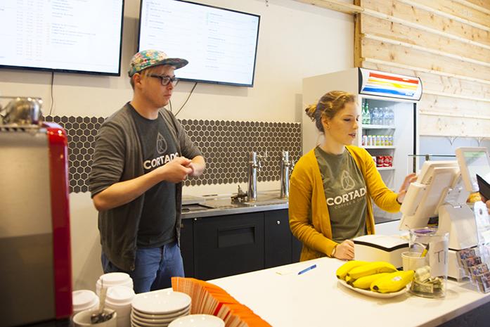 Employees use a cash register at Cortado Coffee &amp; Cafe on S. Clinton st. on Thursday, Feb. 23, 2017. Businesses all over Johnson County will be impacted by the change in minimum wage. (The Daily Iowan/Lily Smith)