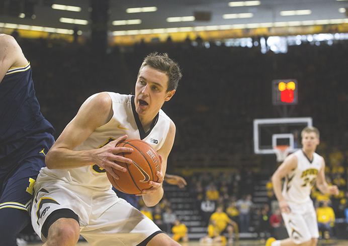 Iowa forward Nicholas Baer attempts a basket under Michigan forward Mortiz Wagner during a mens basketball game in Carver-Hawkeye Arena on Sunday, Jan. 1, 2017. The Hawkeyes defeated the Wolverines, 86-83 in OT. (The Daily Iowan/Joseph Cress)