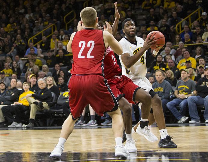 Iowa guard Isaiah Moss attempts a layup past South Dakota's Tyler Peterson and Triston Simpson during a men's basketball first round National Invitation Tournament game against South Dakota in Carver-Hawkeye Arena on Wednesday, March 15, 2017. The Hawkeyes defeated the Coyotes, 87-75. (The Daily Iowan/Joseph Cress)