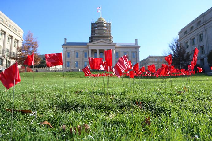 Red flags are placed in the center of the lawn in front of the Old Capitol on Tuesday, November 29, 2016. The red ribbon is a symbol for awareness with illegal drugs, drunk driving, stopping illegal drugs, and people living with HIV/AIDS. (The Daily Iowan/ Alex Kroeze)