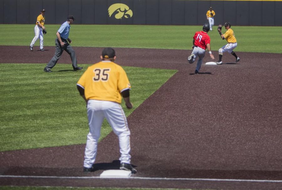 Iowa's Matt Hoeg turns a double play during today's game against Rutgers at Duane Banks Field on Sunday, April 23. The Scarlet Knights went on to defeat the Hawkeyes 13-5. (The Daily Iowan/Ben Smith)