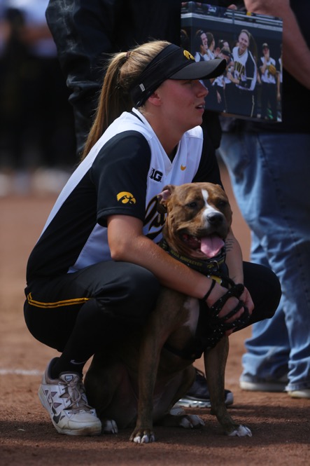Iowa senior Kaitlyn Mullarkey crouches down with her dog wile watching a video after the game between Iowa/Northwestern at Pearl Field on Sunday, May 7, 2017. On Iowas senior day they fell to the Wildcats 5-2. (The Daily Iowan/ Alex Kroeze)