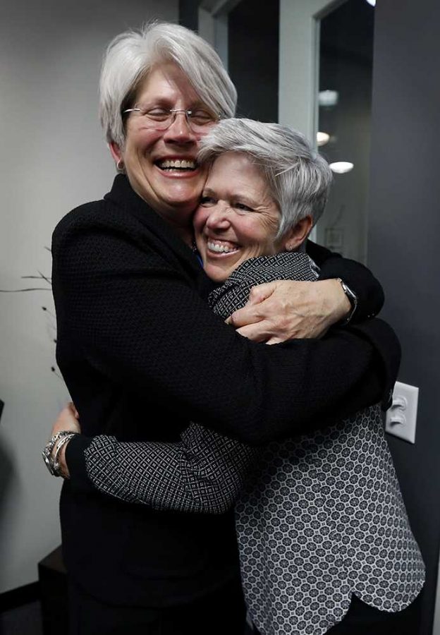 Jane Meyer, former senior associate athletic director at the University of Iowa, gets a hug from her partner Tracey Griesbaum, right, following a news conference, Thursday, May 4, 2017, in Des Moines, Iowa. A jury on Thursday awarded more than $1.4 million to Meyer ruling that the university had discriminated against her because of her gender and sexual orientation. (AP Photo/Charlie Neibergall)