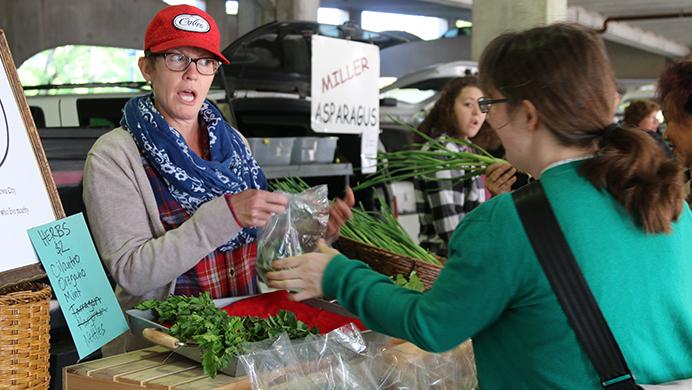 Bonnie Riggan, owner of Calico Farm, sells her product to a customer at the Chauncey Swan Ramp on Wednesday, May 4, 2016. Iowas first farmers market of the year was held at the ramp. (The Daily Iowan/Tawny Schmit)