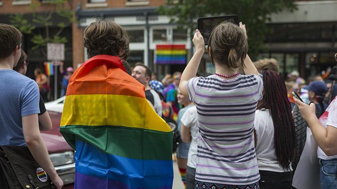 IC Pride parade goers take pictures of Washington St. on Saturday, June 17. The parade is part of Pride Month, a celebration of the LGBTQ community and commemoration of the Stonewall riots of 1969. (Ben Smith/The Daily Iowan)