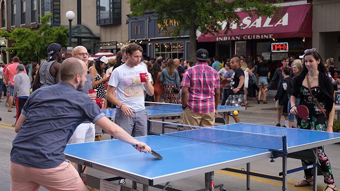 Partygoers play ping pong on Dubuque Street during the Iowa City Downtown District Block Party on Saturday June 25, 2017. The Block Party, hosted by the ICDD was the first use of Iowa City's changed rules allowing open containers for select events downtown (Nick Rohlman/The Daily Iowan)