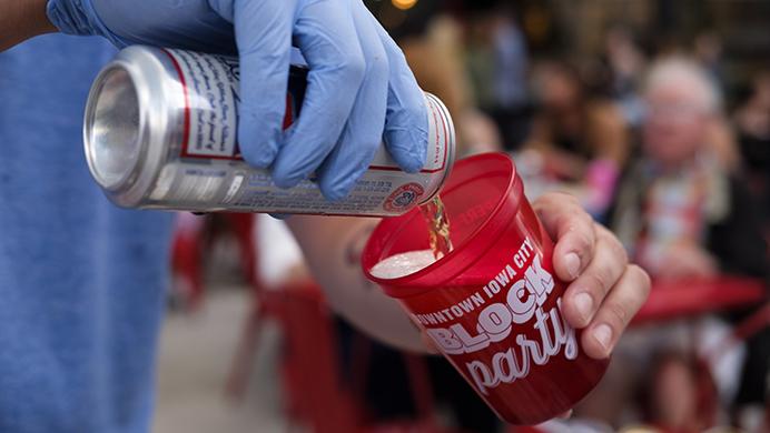 A bartender pours a beer into a block party cup during the Iowa City Downtown District Block Party on Saturday June 25, 2017. The Block Party, hosted by the ICDD was the first use of Iowa City's changed rules allowing open containers for select events downtown. Open containers were permitted only for beer or wine in the approved glasses. (Nick Rohlman/The Daily Iowan)