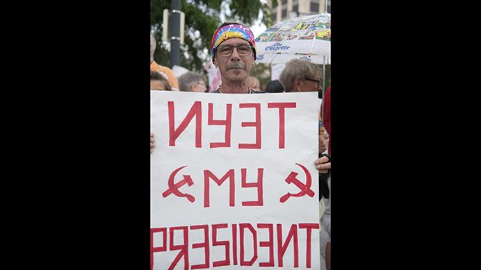 Steve Black-Wolf of Cedar Rapids holds a sign during a protest outside of a Donald Trump rally in Cedar Rapids on wednesday June 21, 2107. Black-Wolf said he was protesting becasue he "strongly oppose[s] everything this president stands for." (Nick Rohlman/The Daily Iowan)