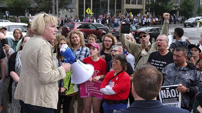 Democratic canidate for govenor Cathy Glasson adresses protestors outside of a Donald Trump rally in Cedar Rapids on Wednesday June 21, 2017. Glasson is president of SEIU local 199, a union chapter representing healthcare workers and school support employees. (The Daily Iowan/Nick Rohlman)