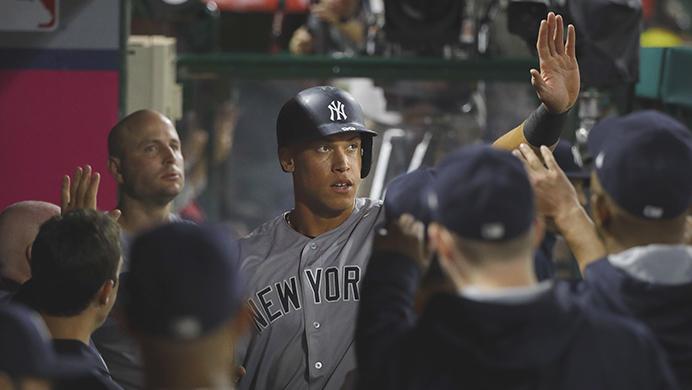New York Yankees Aaron Judge, center, is greeted by teammates in the dugout after scoring on a single hit by Chase Headley during the seventh inning of a baseball game against the Los Angeles Angels, Monday, June 12, 2017, in Anaheim, Calif. (AP Photo/Jae C. Hong)