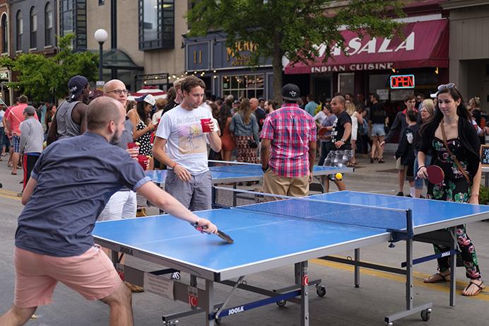 Partygoers play ping pong on Dubuque Street during the Iowa City Downtown District Block Party on Saturday June 25, 2017. The Block Party, hosted by the ICDD was the first use of Iowa City's changed rules allowing open containers for select events downtown (Nick Rohlman/The Daily Iowan)