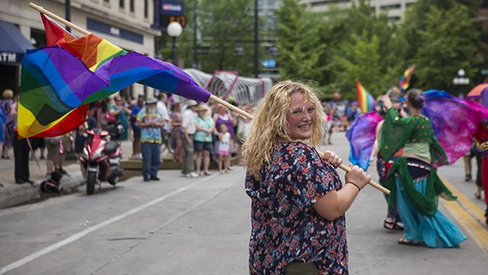 Lexi Ridout, a parade participant, marches on Dubuque St. with flag in hand during the IC Pride Parade on Saturday, June 17. The parade is apart of LBGT Pride Month, established in 1969 to commemorate the Stonewall riots. (Ben Smith/The Daily Iowan)