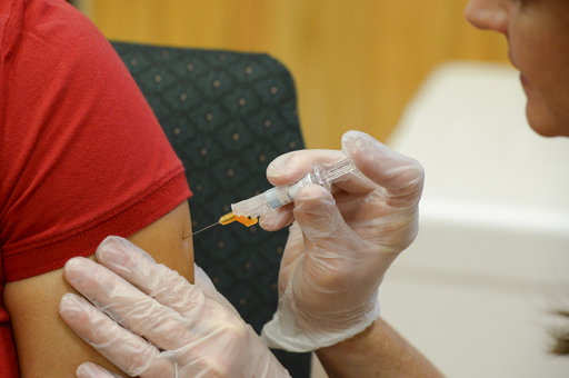 FILE - In this Friday, Sept. 16, 2016 file photo, a woman receives a flu vaccine shot at a community fair in Brownsville, Texas. On Wednesday, June 21, 2017, U.S. health officials released new estimates showing the previous winter’s flu vaccine was ineffective in protecting older Americans against the illness, even though the vaccine was well-matched to the flu bugs going around. (Jason Hoekema/The Brownsville Herald via AP)