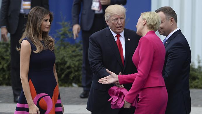 Polands first lady Agata Kornhauser-Duda, second right, reaches her hand to U.S. First Lady Melania Trump as U.S. President Donald Trump reaches his hand for a handshake after his speech in Krasinski Square, with Polish President Andrzej Duda standing right, in Warsaw, Poland, Thursday, July 6, 2017. (AP Photo/Alik Keplicz)