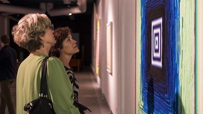 Attendees of the Jazz vestival view artwork at RADinc in Iowa City on Sunday July 2, 2017. Th artwork, John Schule's EatChewALive project, is a combination of felt and oil paint and is meant to be a sensory experience. The work was displayed as a visual complement to the music of Jazz Fest. (Nick Rohlman/The Daily Iowan)