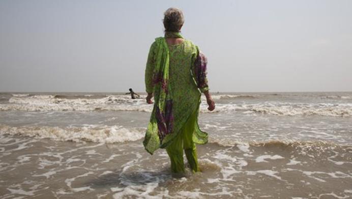 In this April 13, 2017 photo, Elizabeth Brenner, who is following the last footsteps of her son in India, enters the Gangasagar beach in West Bengal state, where the Ganges river flows into the Bay of Bengal. Brenners son Thomas Plotkin, died during a study abroad trip to the mountains of India more than five-years-ago. His body was never found. Brenner spent two months tracing the 1,037 mile path along the Ganges River as she believes this is the path taken by her sons remains. (AP Photo/Rishabh R. Jain)