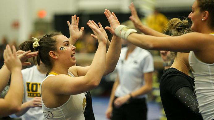 FILE - After a successful vault, Hawkeye Angel Metcalf high-fives teammate Tessa Walsh during the Black/Gold meet in the Field House on Dec. 3, 2016. Walsh is currently training with the rowing team after two years as a GymHawk. (Osama Khalid/The Daily Iowan, file)