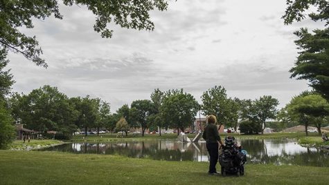 Stella Turnbull and her caretaker, Shelly, look out over the pond at Morrison Park in Coralville on Tuesday, July 11, 2017. Within the first year of her life, Stella developed progressive muscular atrophy, a rare condition which affects the lower motor neurons, qualifying her for Medicaid under the pre-existing conditions clause. The Turnbull family relies on insurance to pay for Stella’s healthcare. With the AHCA still a topic of debate in Washington, the future of Medicare and Medicaid are still unsure. (Ben Smith/The Daily Iowan)