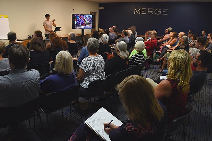 Iowa City community mebers listen to some upcoming public art projects at Merge collective workspace, Wednesday, Aug. 30, 2017. The Iowa City Downtown District hosted the event to gather input from the community on possible art projects through the district. (Paxton Corey/The Daily Iowan)