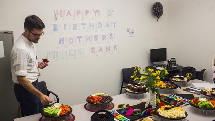 Mother’s Milk Bank intern and senior at the University of Iowa Samuel Allison selects a treat out of the assortment of snacks during the bank's 15th birthday party on Tuesday, Aug 1, 2017. (Jim Geeredes/The Daily Iowan)